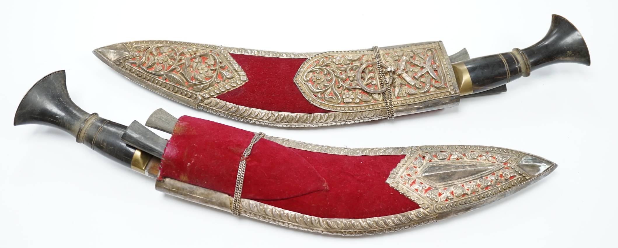 A pair of Indian Kukri, c.1950, brass mounted horn hilts, in velvet sheaths with embossed silver mounts. Condition - fair to good